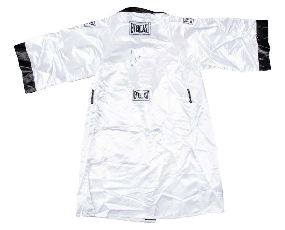 Muhammad Ali Signed Everlast Boxing Robe PSA DNA COA: Muhammad Ali Signed Everlast Boxing Robe PSA DNA COA This original Everlast boxing robe, crafted from white satin, is a remarkable piece of sports memorabilia signed by the legendary Muhammad Ali in b