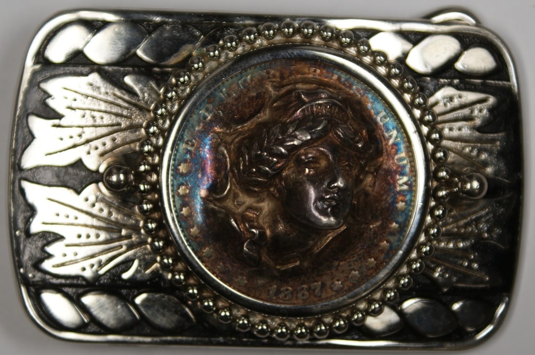 Belt Buckle Set With 1887 Morgan Silver Dollar Obverse Removed Nicely Toned: Belt Buckle Set With 1887 Morgan Silver Dollar Obverse Removed Nicely Toned This item is a belt buckle featuring an 1887 Morgan Silver Dollar from the United States. The obverse of the coin has been p