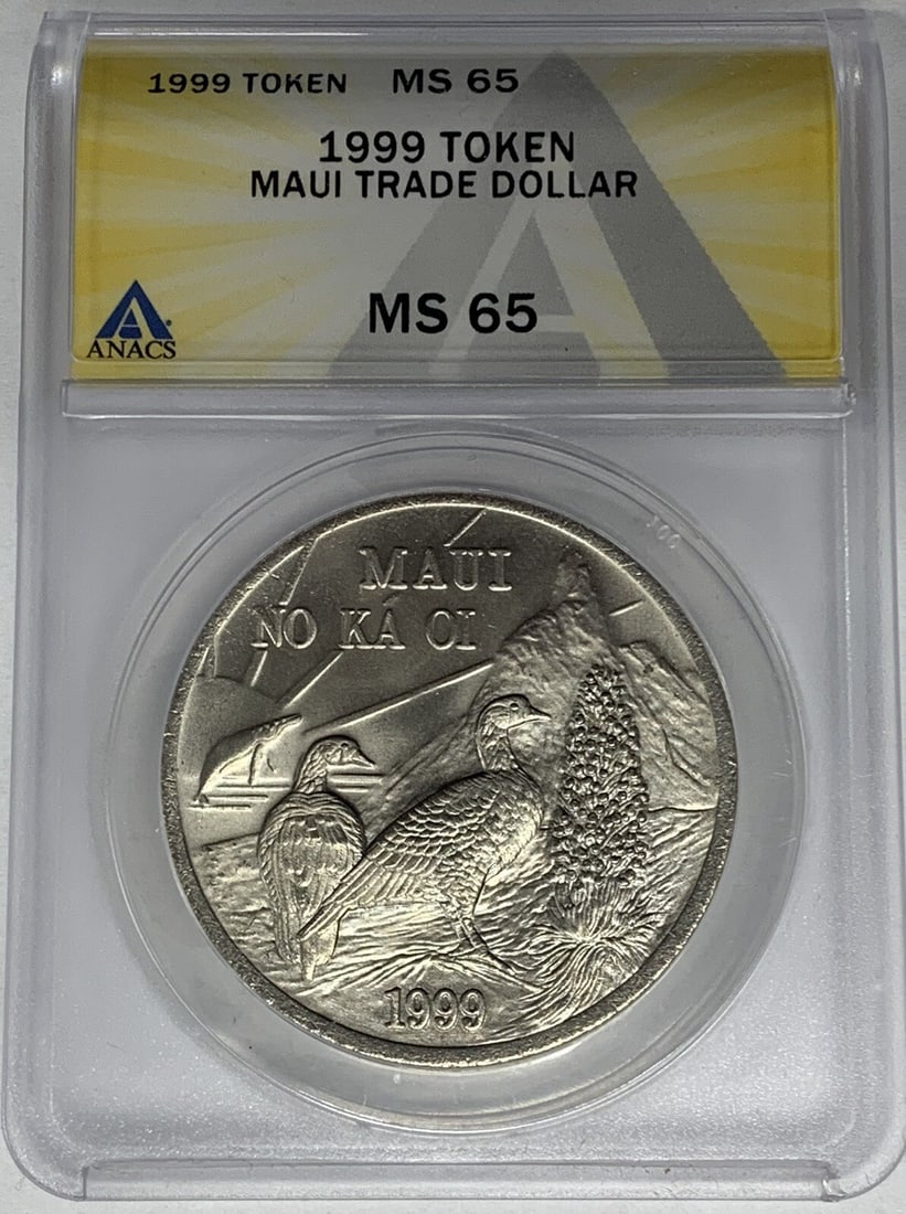 1999 Maui Trade Dollar Token Graded MS 65 by ANACS: 1999 Maui Trade Dollar Token Graded MS 65 by ANACS This is a 1999 Maui Trade Dollar token certified by ANACS with a grade of MS 65. The token is from the United States and is in un-used, pre-owned con
