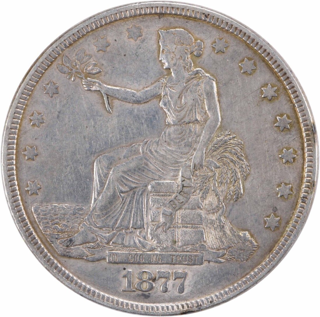 1877 Trade Silver Dollar XF Uncertified William Barber Design: 1877 Trade Silver Dollar XF Uncertified William Barber Design This 1877 Trade Silver Dollar is a remarkable piece of history, showcasing the artistry of designer William Barber. With a composition of