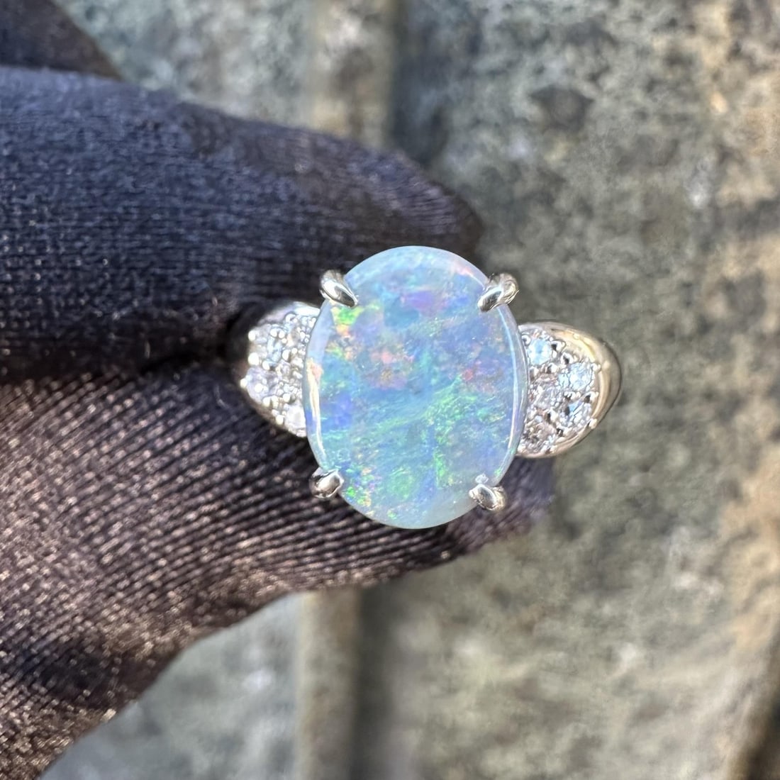 Platinum Oval Gray Opal and Diamond Pave Accent Cocktail Ring 1.61ctw: Platinum Oval Gray Opal and Diamond Pave Accent Cocktail Ring 1.61ctw This platinum cocktail ring features a natural oval gray opal cabochon as the center stone, exhibiting a vibrant play of green and