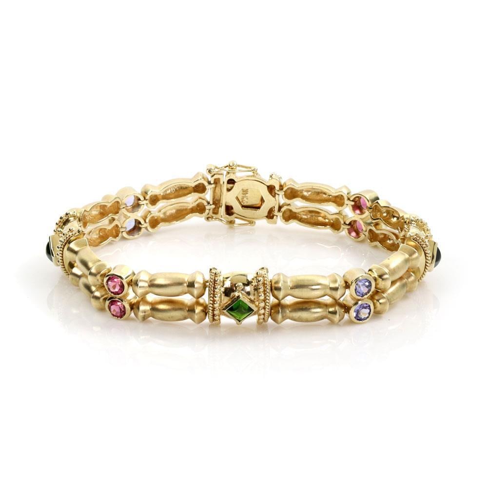 Vintage 14k Yellow Gold Bracelet with Tanzanite Pink Green Tourmaline: Vintage 14k Yellow Gold Bracelet with Tanzanite Pink Green Tourmaline This exquisite vintage bracelet showcases a stunning design crafted from 14k yellow gold with a satin finish. The bracelet feature