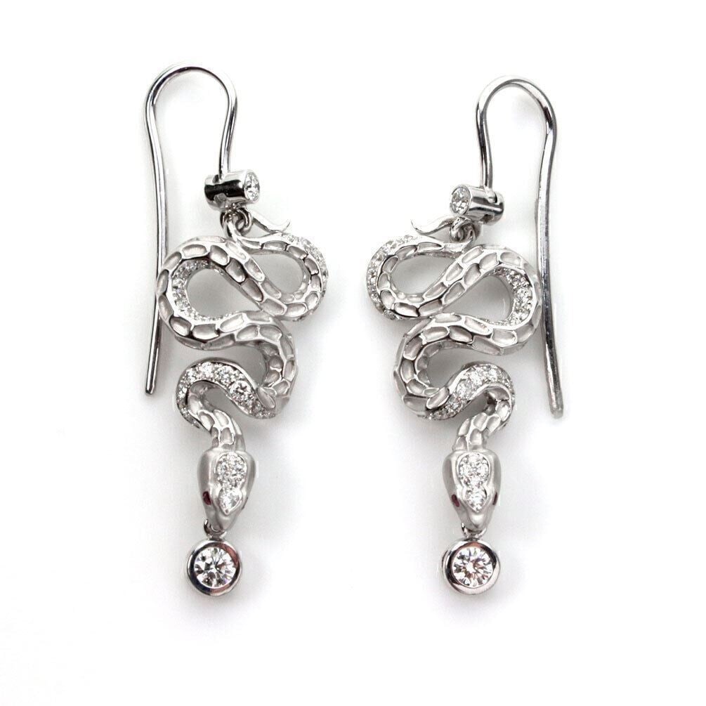 Coiled Snake Dangle Earrings in 18k White Gold with Diamonds and Red Sapphires: Coiled Snake Dangle Earrings in 18k White Gold with Diamonds and Red Sapphires These Magerit dangle earrings feature a coiled snake design crafted from 18k white gold, accented with diamonds and red s
