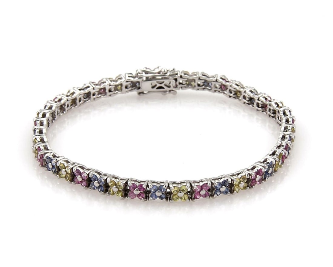 Star Motif 18k White Gold Tennis Bracelet With Multicolor Sapphires: Star Motif 18k White Gold Tennis Bracelet With Multicolor Sapphires This tennis bracelet features pink, blue, and yellow sapphires arranged in a unique star shape design, set in 18k white gold. The br