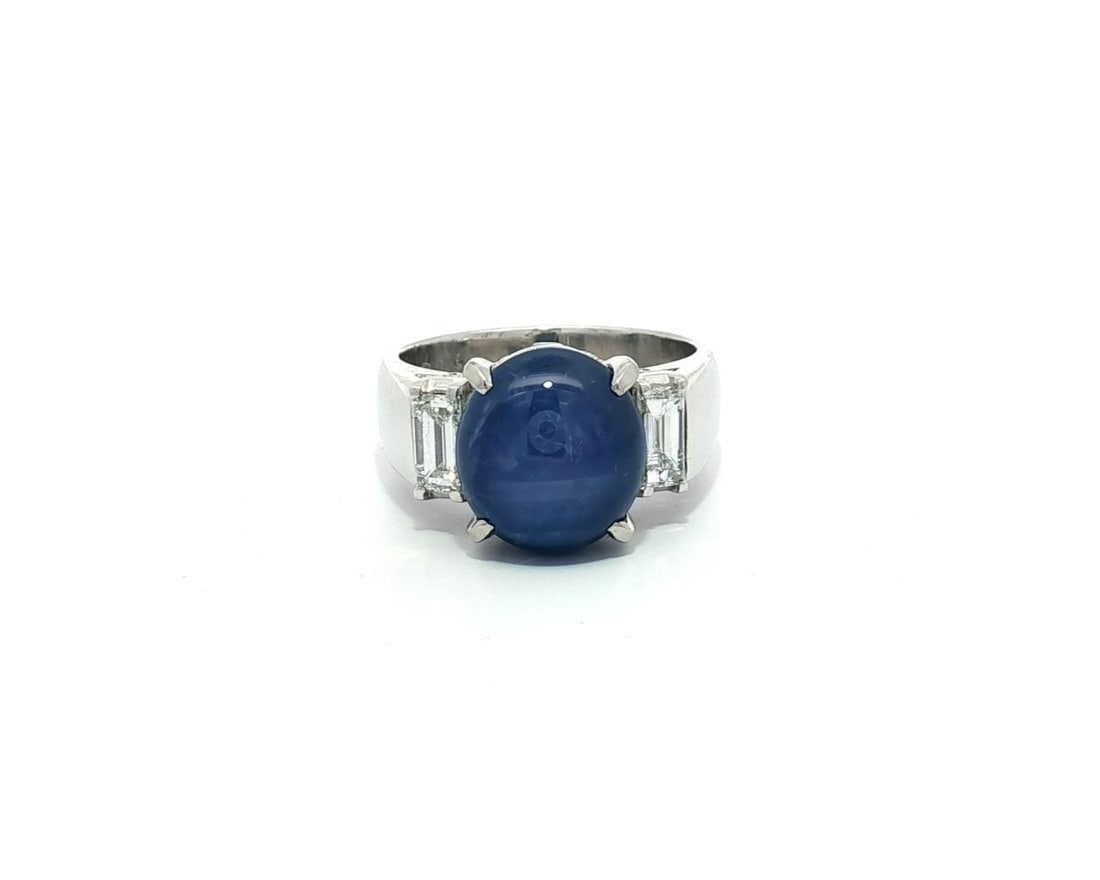 Elegant Vintage Platinum Blue Star Sapphire Ring with Baguette Diamonds: Elegant Vintage Platinum Blue Star Sapphire Ring with Baguette Diamonds This exquisite vintage ring showcases a stunning natural blue star sapphire at its center, elegantly complemented by two baguett