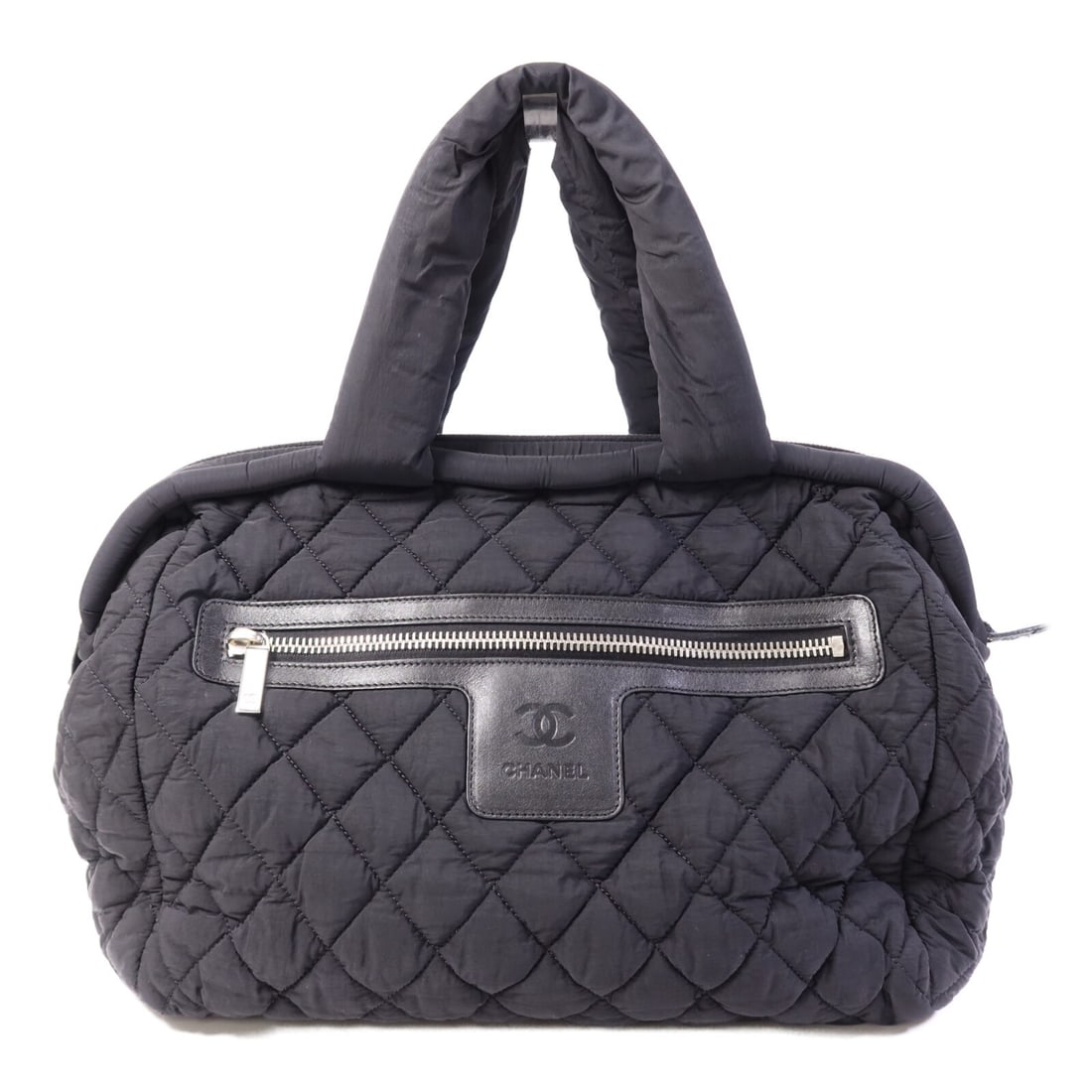 Chanel Coco Cocoon Black Nylon Handbag with Silver Tone CC Logo: Chanel Coco Cocoon Black Nylon Handbag with Silver Tone CC Logo This Chanel Coco Cocoon handbag features a black nylon exterior and offers ample space with its regular size. Crafted in France, the bag