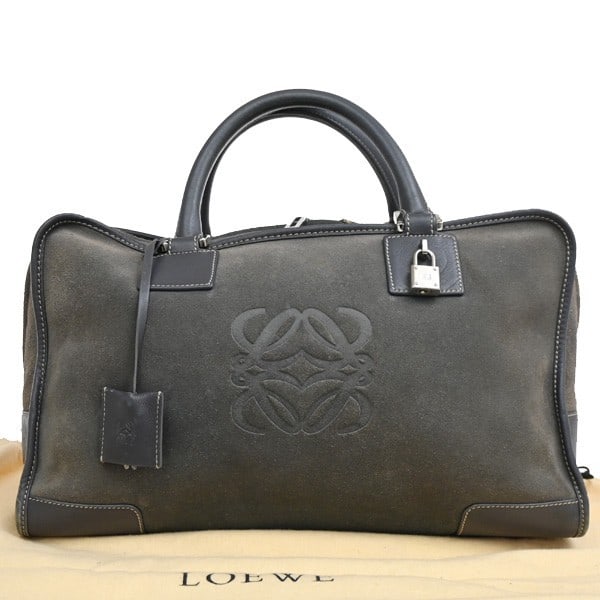 Loewe Amazona Gray Suede Handbag 24cm by 21cm by 15cm: Loewe Amazona Gray Suede Handbag 24cm by 21cm by 15cm This pre-owned Loewe Amazona handbag features a gray suede exterior with signs of use including scuffs, dirt, and pilling. The interior shows some