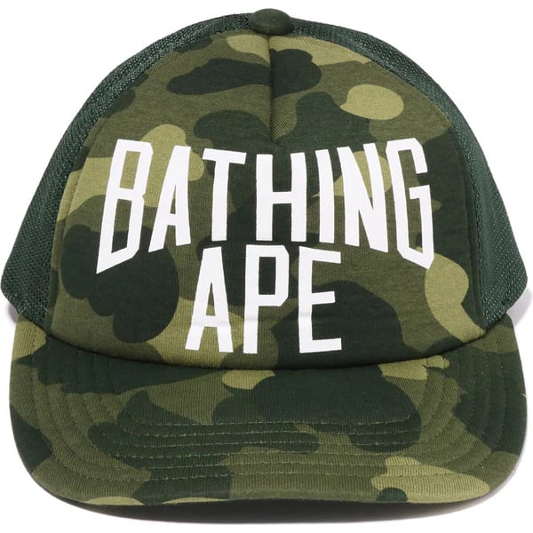 Green Mesh Trucker Hat with BAPE Camo and NYC Embroidery: Green Mesh Trucker Hat with BAPE Camo and NYC Embroidery This A Bathing Ape Color Camo NYC Logo Green Mesh Cap features a trucker-style design with BAPE's signature color camo pattern and a bold NYC l