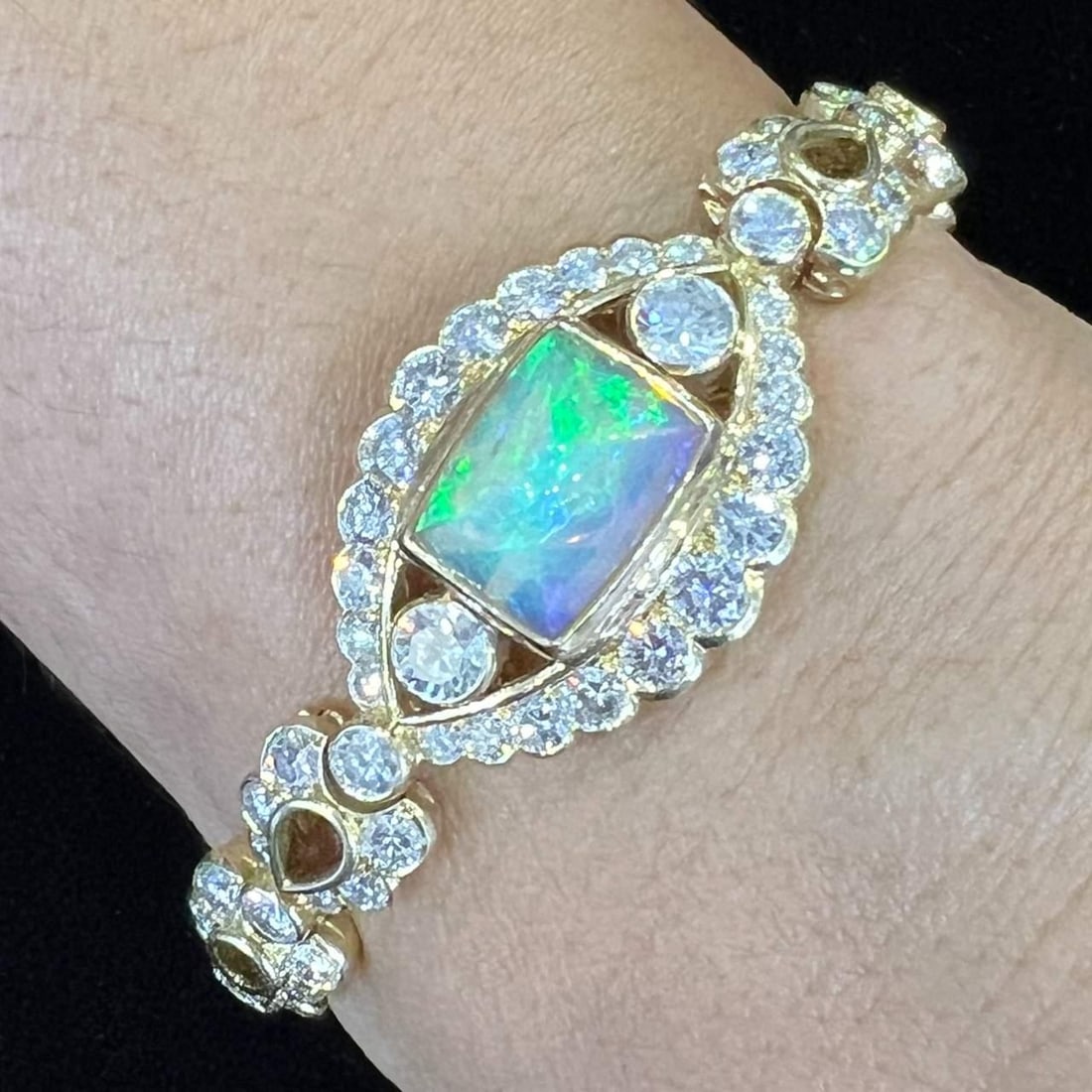 18K Yellow Gold 4.92 Ct Opal Diamond Bracelet 108 Stones: 18K Yellow Gold 4.92 Ct Opal Diamond Bracelet 108 Stones This exquisite 18K Yellow Gold bracelet features a stunning 4.92 Ct. Sugarloaf Opal, complemented by a total of 108 sparkling diamonds weighing