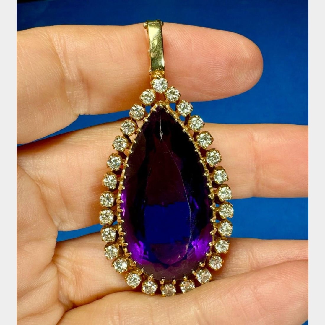 14K Yellow Gold Amethyst Diamond Pendant 45 Ct 28 Stones: 14K Yellow Gold Amethyst Diamond Pendant 45 Ct 28 Stones This exquisite pendant showcases a stunning 33 x 18mm Amethyst, weighing approximately 45.00 ct, beautifully complemented by 28 sparkling Diamo