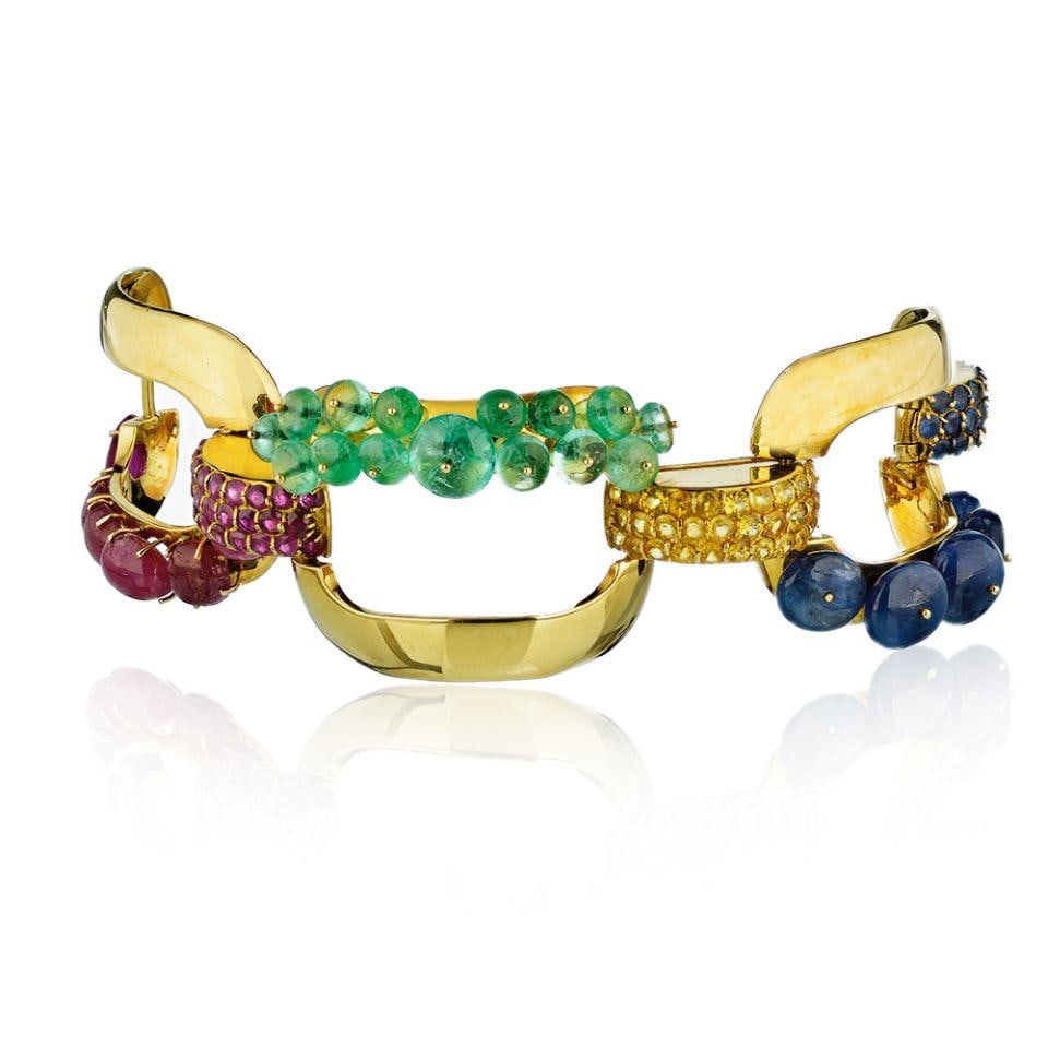 Three Link 18K Gold Bracelet with Ruby Emerald Lapis and Sapphire Clasp 1950s: Three Link 18K Gold Bracelet with Ruby Emerald Lapis and Sapphire Clasp 1950s This circa 1950's three-link bracelet is crafted from 18K yellow gold and showcases a vibrant combination of rubies, emera
