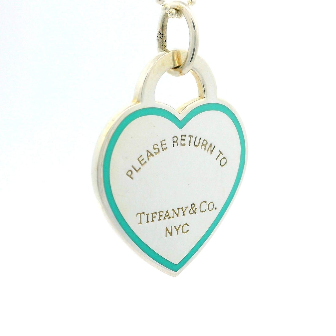 Tiffany & Co. Sterling Silver Blue Enamel Heart Pendant Necklace 25mm: Tiffany & Co. Sterling Silver Blue Enamel Heart Pendant Necklace 25mm This exquisite pendant necklace showcases a heart-shaped design crafted from high-quality sterling silver, adorned with the iconic