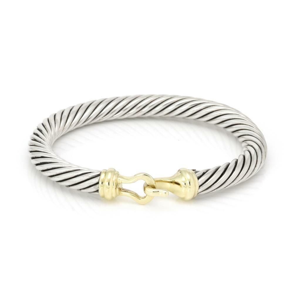David Yurman 14k Yellow Gold Sterling Silver Cable Bracelet: David Yurman 14k Yellow Gold Sterling Silver Cable Bracelet This exquisite bangle from David Yurman showcases a blend of luxurious materials with its sterling silver body and 14k yellow gold accents.