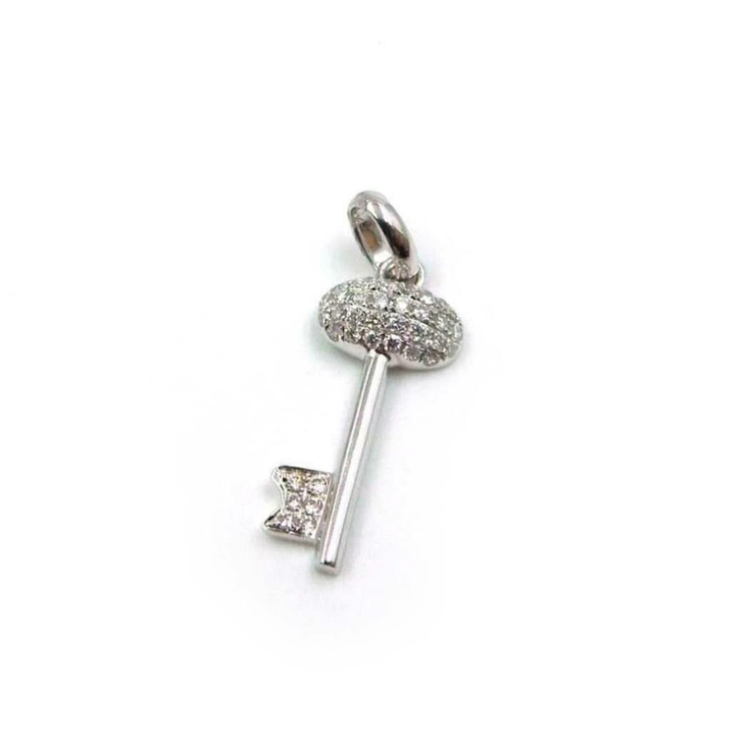 18k White Gold Miniature Diamond Oval Top Key Pendant Charm: 18k White Gold Miniature Diamond Oval Top Key Pendant Charm This mini diamond oval top key charm pendant is crafted from 18k white gold and features a unique oval-topped key design. Adorned with 0.20c