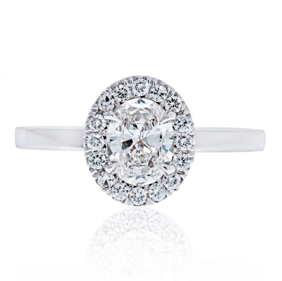 0.66 Carat GIA F VS1 Oval Diamond Halo Engagement Ring in 14K White Gold: 0.66 Carat GIA F VS1 Oval Diamond Halo Engagement Ring in 14K White Gold This stunning engagement ring features a halo design with a captivating 0.66 carat oval cut diamond, GIA certified for its exce