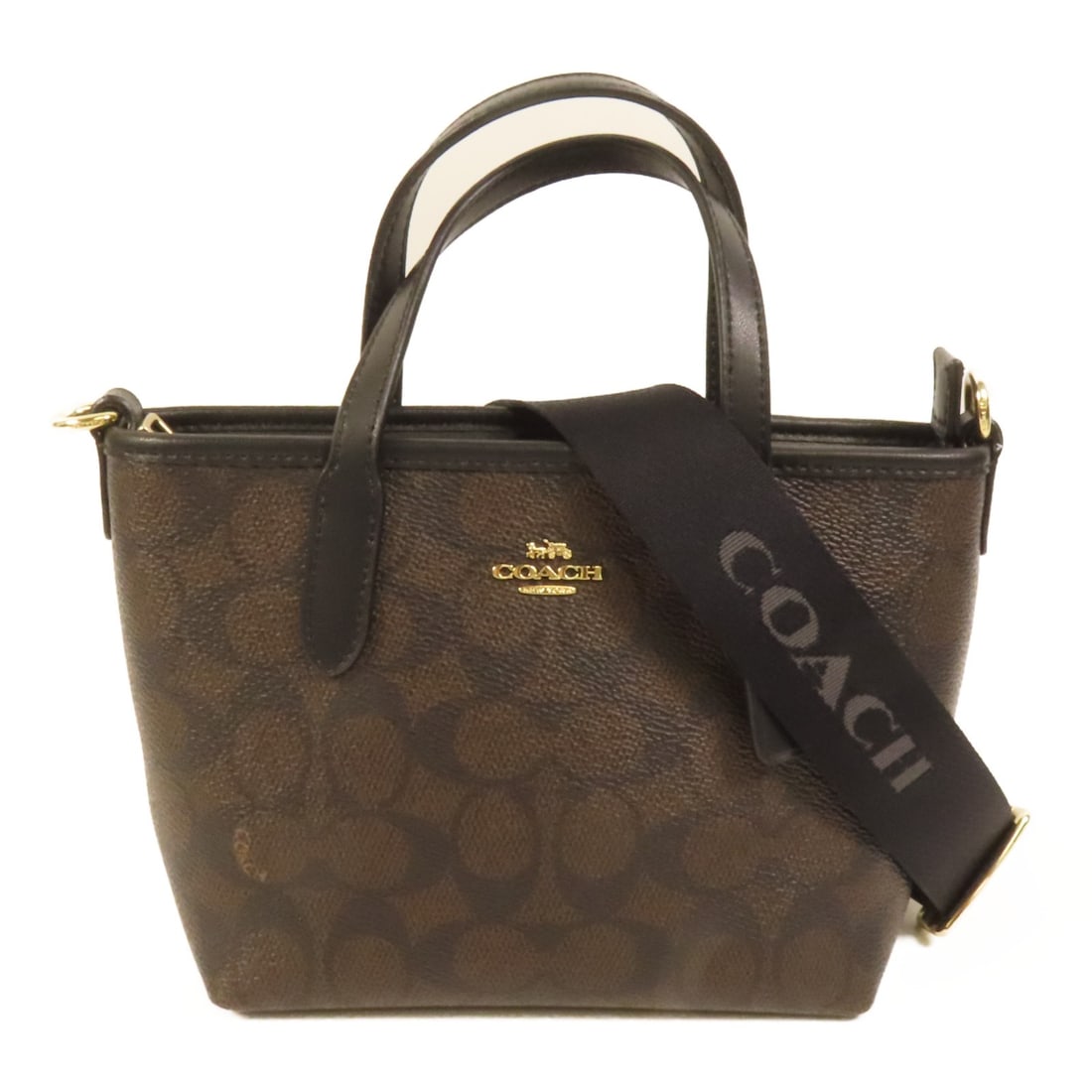 Coach Brown PVC Coated Canvas Two Way Shoulder Bag with Gold Hardware: Coach Brown PVC Coated Canvas Two Way Shoulder Bag with Gold Hardware This COACH 2-way shoulder bag is crafted from durable PVC coated canvas in a brown color. Its versatile design allows for multiple