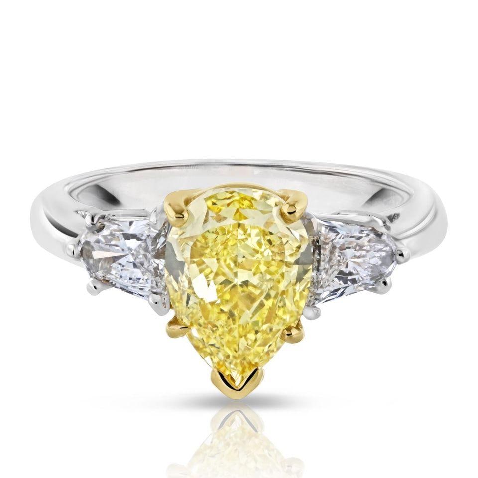 2.24 Carat GIA Pear Cut Fancy Yellow Diamond Ring in Platinum and 18K Gold: 2.24 Carat GIA Pear Cut Fancy Yellow Diamond Ring in Platinum and 18K Gold This exquisite three-stone engagement ring features a stunning 2.24 carat pear cut natural fancy yellow diamond with intense