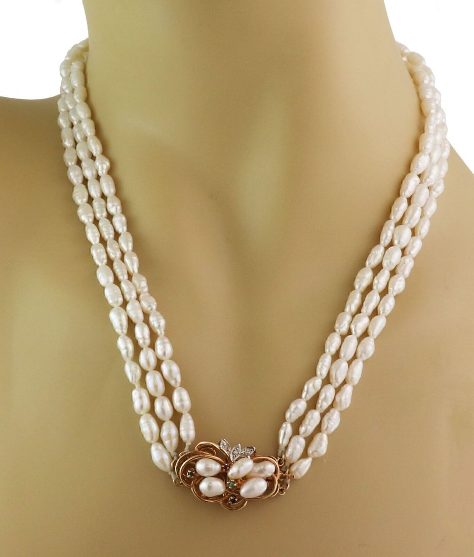 Three Strand Freshwater Rice Pearls Necklace With 14k Gold Gemstone Clasp: Three Strand Freshwater Rice Pearls Necklace With 14k Gold Gemstone Clasp This vintage necklace features three strands of freshwater rice pearls, elegantly draping around the neckline. The ornate clas