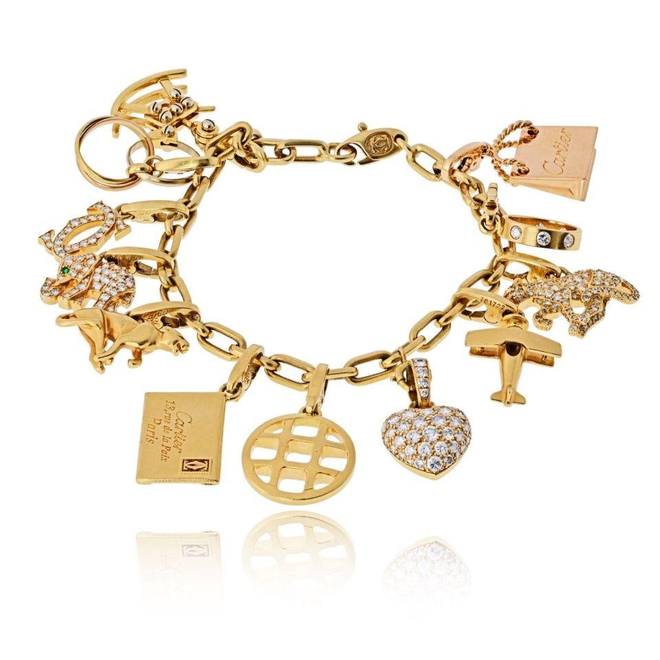 Santos 12 Charm 18K Yellow Gold Bracelet with Box and Papers by Cartier: Santos 12 Charm 18K Yellow Gold Bracelet with Box and Papers by Cartier This Cartier Santos charm bracelet is crafted from solid 18K yellow gold and features a classic Santos link design. The bracelet
