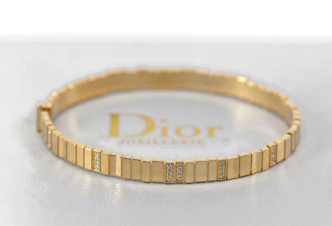 Dior 18K Yellow Gold Diamond Bangle Bracelet with Box and Certificate Size 16: Dior 18K Yellow Gold Diamond Bangle Bracelet with Box and Certificate Size 16 This Christian Dior bracelet features a bangle style crafted from 18K yellow gold and is adorned with diamonds. It is a si
