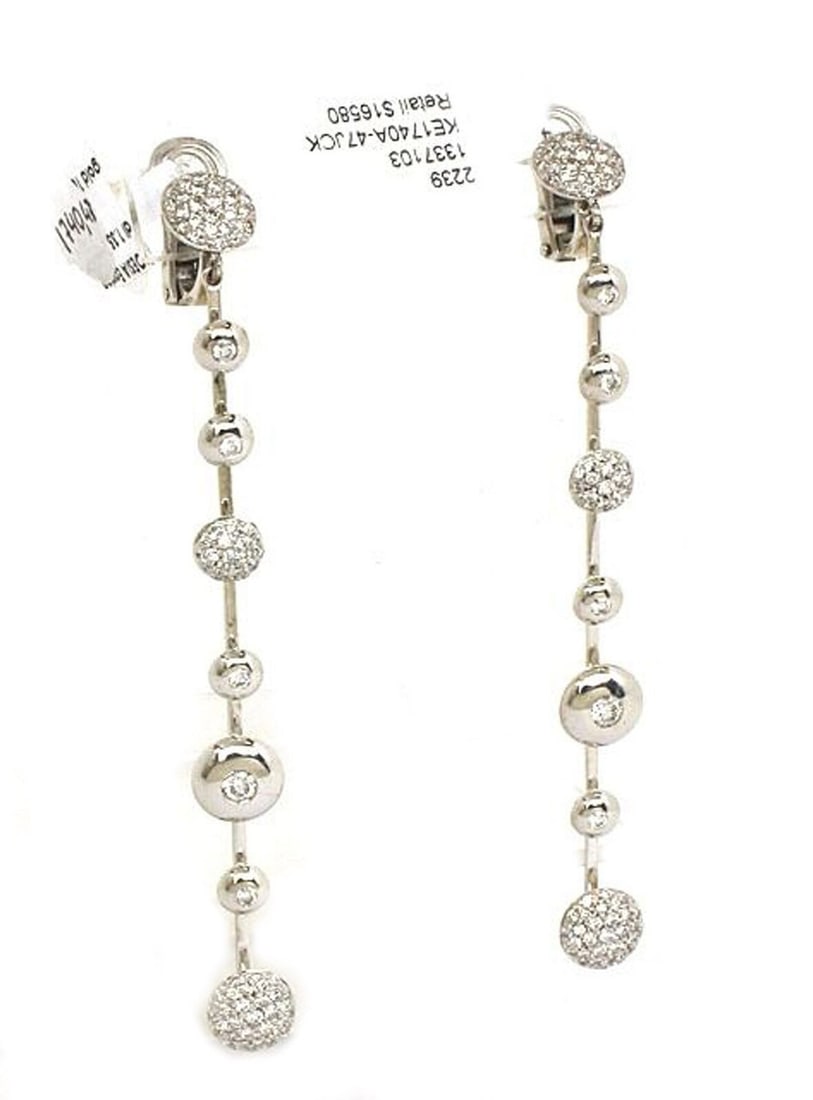 18k White Gold Diamond Drop Earrings by Koesia Italy Turning Disc Design: 18k White Gold Diamond Drop Earrings by Koesia Italy Turning Disc Design These elegant earrings by Koesia are crafted in 18k white gold and feature a distinctive turning disc design. Accented with 1.3