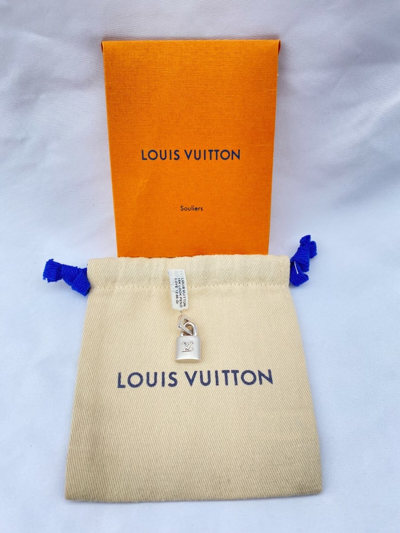 Louis Vuitton 18K White Gold Charm with Bag and Box: Louis Vuitton 18K White Gold Charm with Bag and Box This exquisite charm by Louis Vuitton is crafted from 18K white gold, showcasing exceptional detail and craftsmanship. It can be versatilely worn as