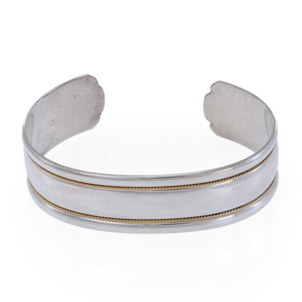 Tiffany & Co. Cuff Bracelet Sterling Silver 18k Yellow Gold Rope Design: Tiffany & Co. Cuff Bracelet Sterling Silver 18k Yellow Gold Rope Design This exquisite cuff bracelet from Tiffany & Co. showcases a harmonious blend of sterling silver and 18k yellow gold. The high-po