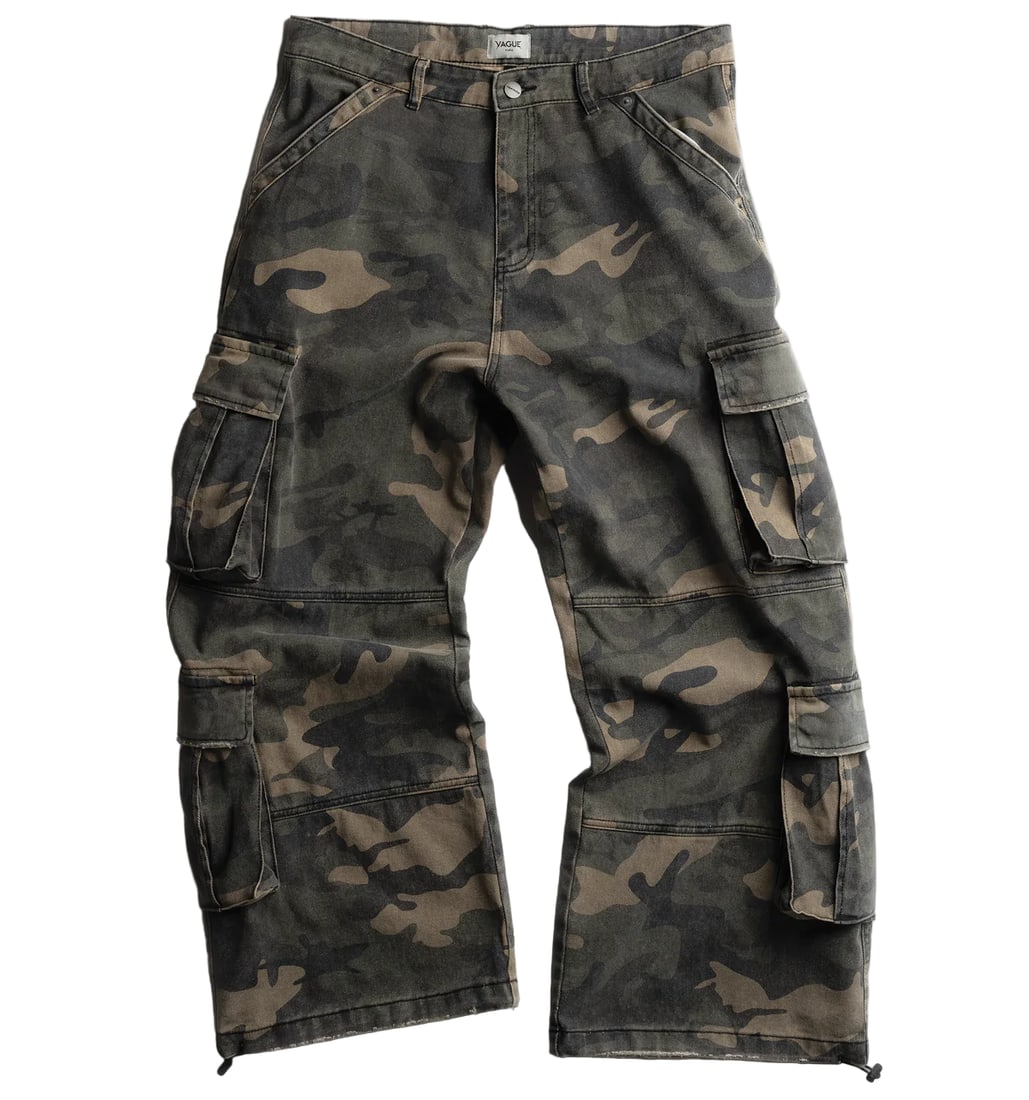 Woodland Camouflage Relaxed Fit Cargo Pants by Vague Precious: Woodland Camouflage Relaxed Fit Cargo Pants by Vague Precious Experience a blend of rugged outdoor style and modern streetwear with the Vague Precious Woodland Camo Cargo Pants. Featuring a woodland c