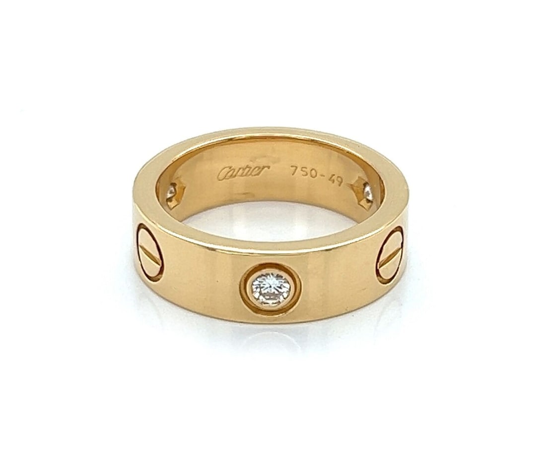 Three Diamond 18k Yellow Gold Cartier Love Band Ring Size 5 With Certificate: Three Diamond 18k Yellow Gold Cartier Love Band Ring Size 5 With Certificate This Cartier Love ring is crafted in 18k yellow gold and features three diamonds with a total weight of 0.22 ct. The band h