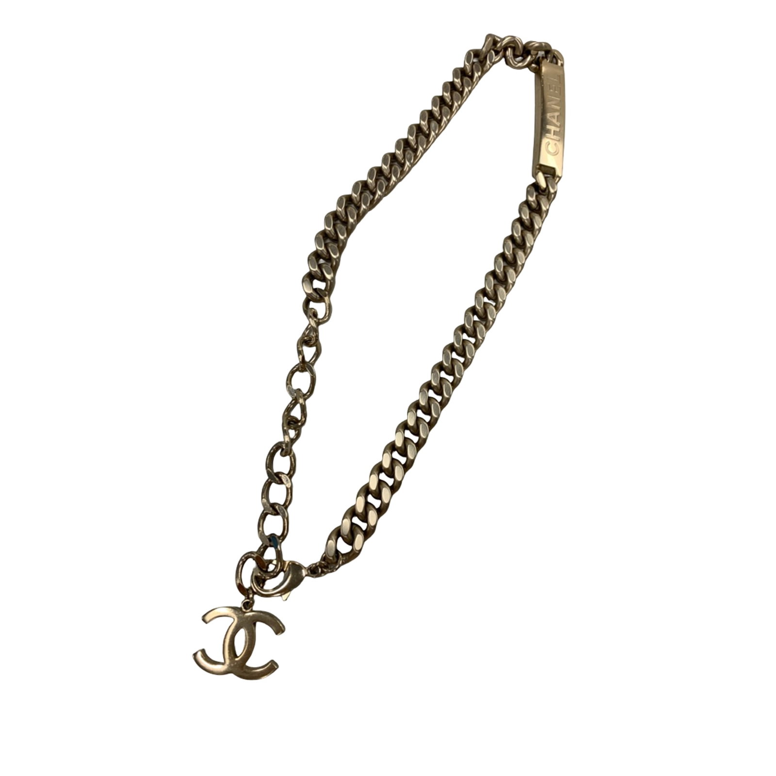 Chanel Gold Tone Curb Link Necklace with ID Plate: Chanel Gold Tone Curb Link Necklace with ID Plate This Chanel necklace features a gold-tone metal body in a classic curb link chain design with an ID plate and lobster clasp closure. The piece is cate