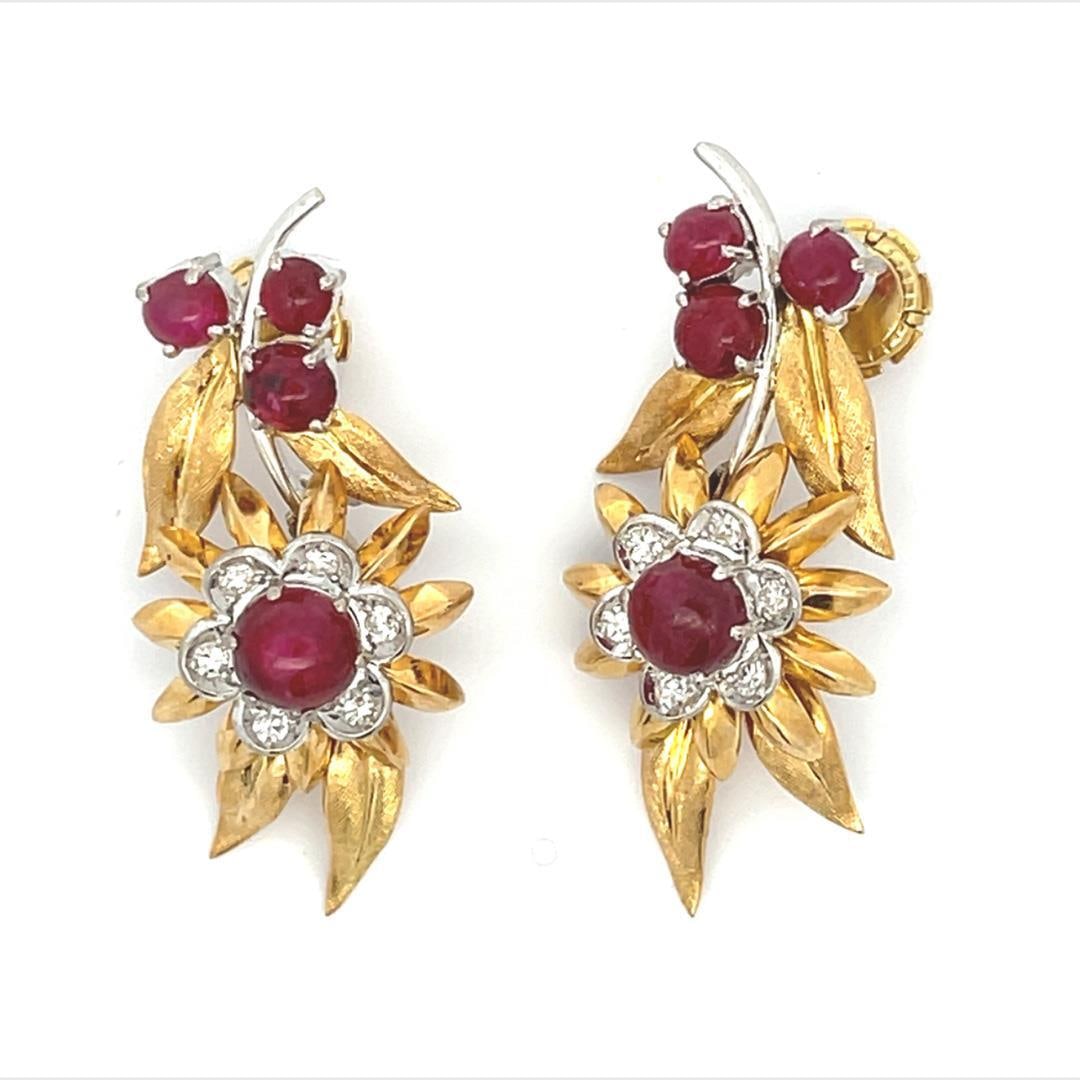 Floral Dangle Earrings 18k Two Tone Gold Diamond Ruby: Floral Dangle Earrings 18k Two Tone Gold Diamond Ruby These exquisite dangle earrings are designed in a stunning floral motif, crafted from 18k yellow and white gold. The earrings showcase a delicate