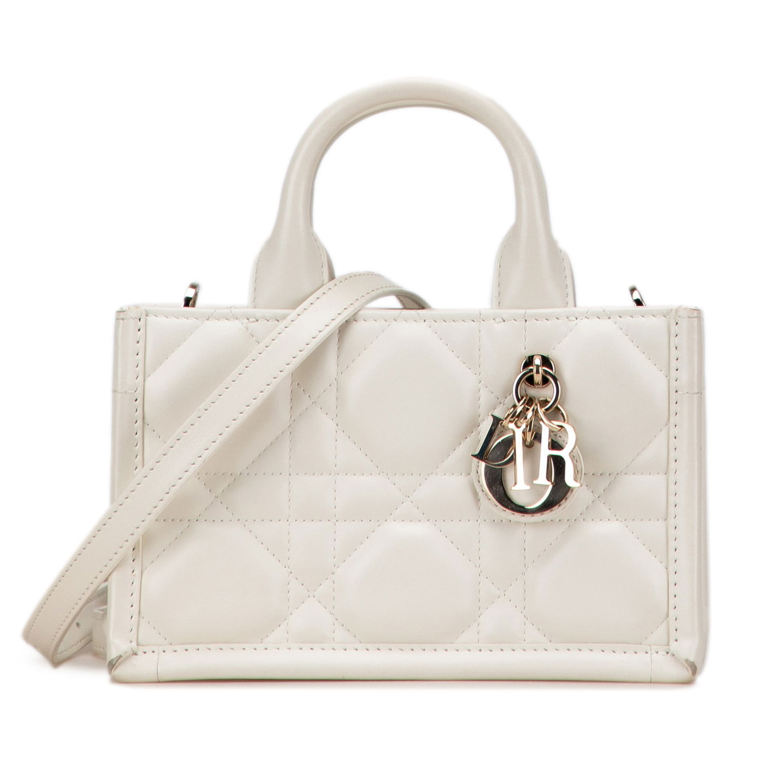 Dior Mini Calfskin Macrocannage Book Tote in White: Dior Mini Calfskin Macrocannage Book Tote in White The Dior Mini Calfskin Macrocannage Book Tote is a sophisticated and stylish bag crafted from premium leather. This elegant tote features a structure