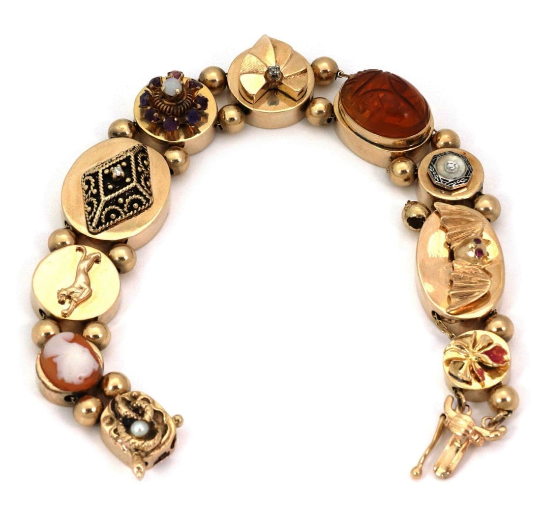 Vintage 10 Slide 14k Yellow Gold Charm Bracelet With Diamonds and Gemstones: Vintage 10 Slide 14k Yellow Gold Charm Bracelet With Diamonds and Gemstones This vintage charm bracelet is crafted from 14k yellow gold and features ten unique slides adorned with gemstones including