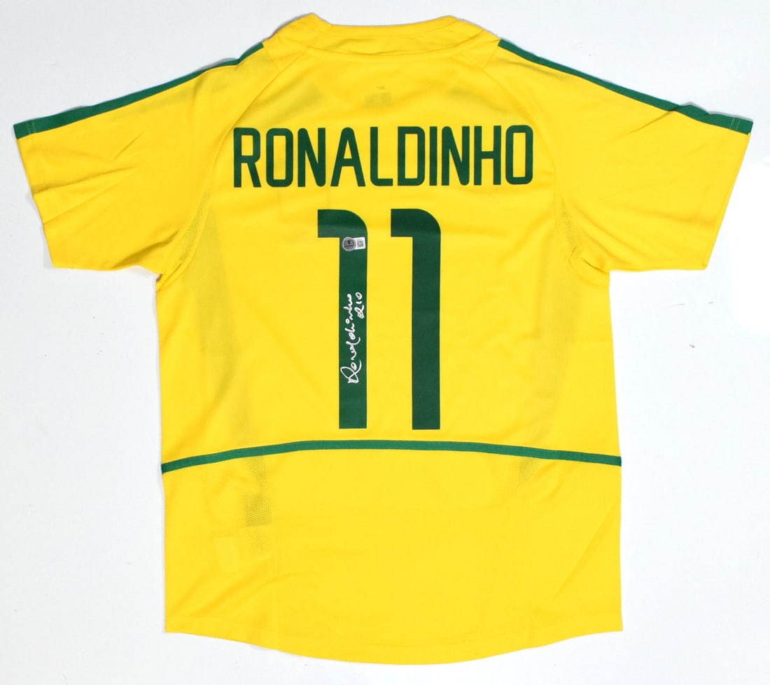 Ronaldinho Signed Brazil Jersey #11 with Beckett Holo: Ronaldinho Signed Brazil Jersey #11 with Beckett Holo Celebrate the legacy of the football legend Ronaldinho with this autographed Brazil home soccer jersey. This original piece showcases the iconic #
