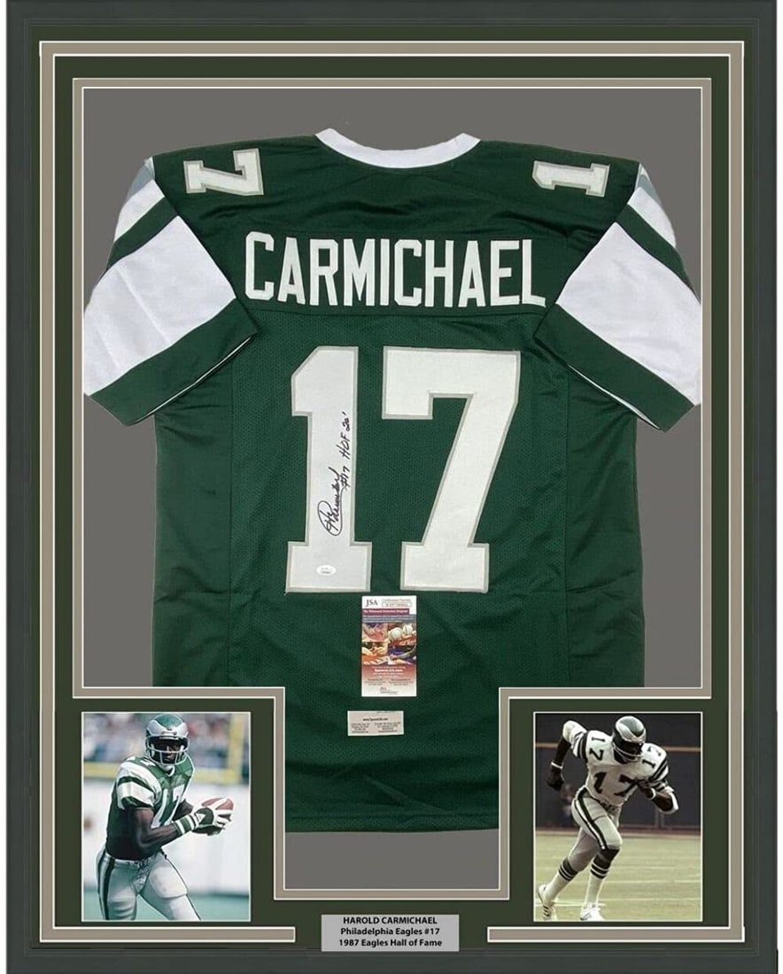 Framed Autographed Harold Carmichael Green Jersey HOF 20 JSA COA: Framed Autographed Harold Carmichael Green Jersey HOF 20 JSA COA Celebrate the legacy of Harold Carmichael with this professionally framed and autographed green jersey. Measuring 35 inches by 39 inche