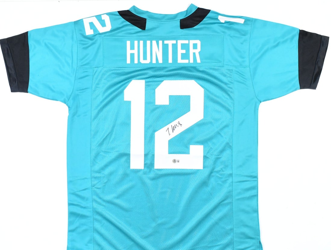 Teal Jacksonville Jaguars Jersey Signed by Travis Hunter Beckett W Authenticated: Teal Jacksonville Jaguars Jersey Signed by Travis Hunter Beckett W Authenticated This Travis Hunter teal pro style jersey features his autograph and comes with a Beckett W hologram for verification. R