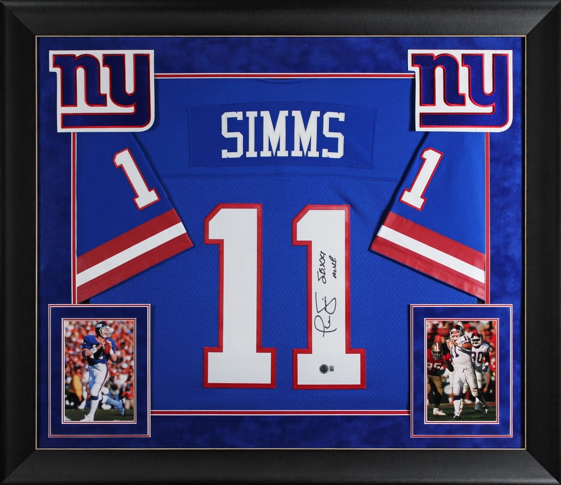 Phil Simms Signed Blue Giants Framed Jersey SB XXI MVP BAS Authenticated: Phil Simms Signed Blue Giants Framed Jersey SB XXI MVP BAS Authenticated Celebrate the legacy of Phil Simms with this original signed blue Mitchell & Ness framed jersey, featuring the inscription 'SB
