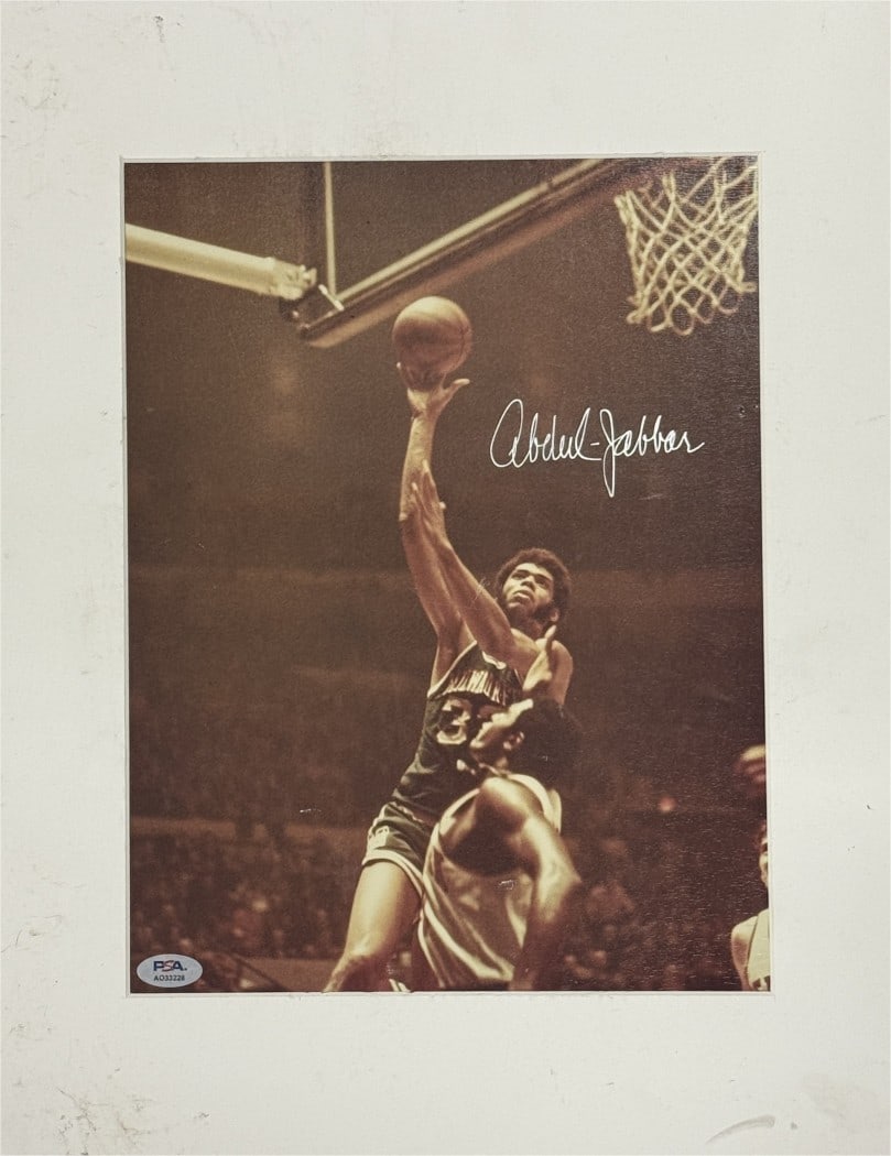 10x12 Matted Photo Signed by Kareem Abdul-Jabbar PSA Authenticated: 10x12 Matted Photo Signed by Kareem Abdul-Jabbar PSA Authenticated This is a 10x12 matted photo autographed by Kareem Abdul-Jabbar, featuring his time with the Los Angeles Lakers. The photograph is an