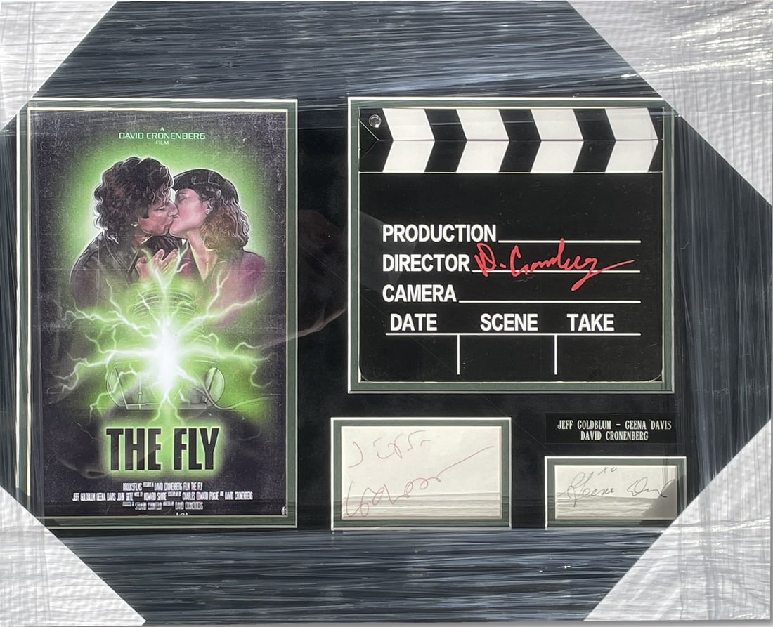 The Fly Framed Clapperboard Signed by Goldblum Davis Cronenberg Beckett Authenticated: The Fly Framed Clapperboard Signed by Goldblum Davis Cronenberg Beckett Authenticated This original photograph features the iconic cast of "The Fly," autographed by Jeff Goldblum, Geena Davis, and dir