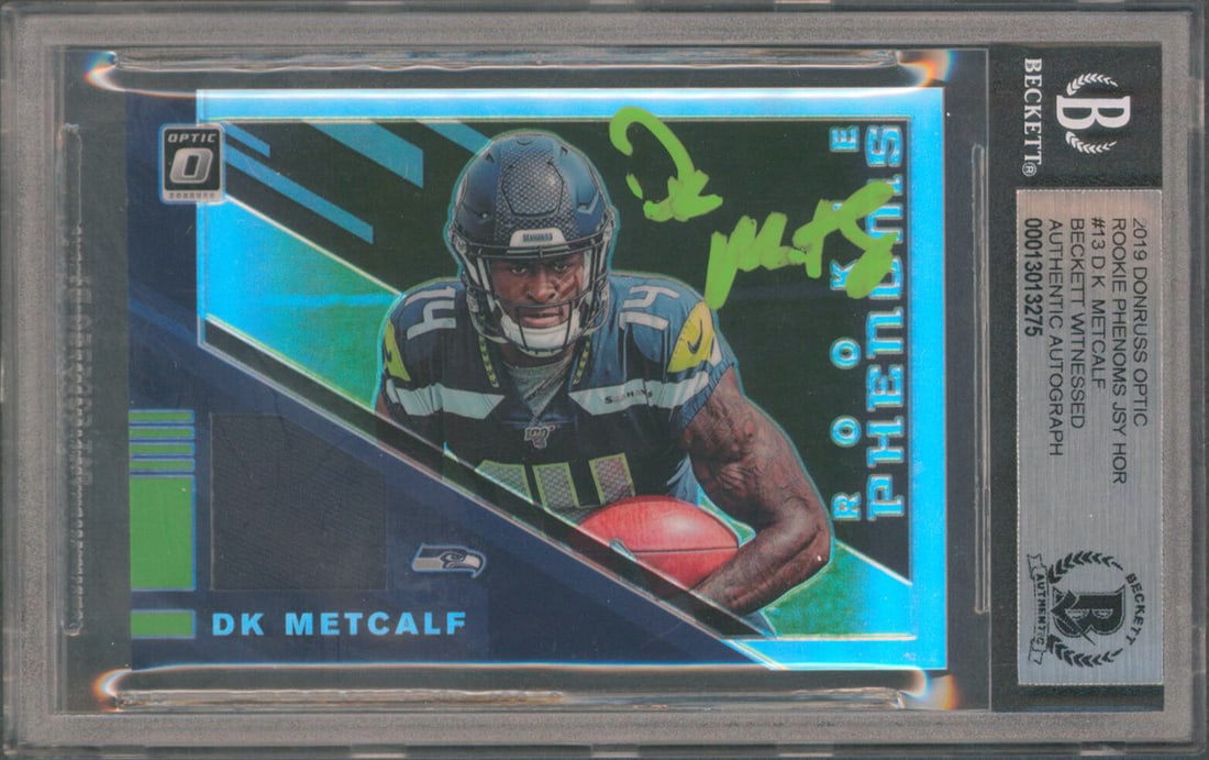 DK Metcalf Signed 2019 Donruss Optic Rookie Card #13 Slabbed Beckett Certified: DK Metcalf Signed 2019 Donruss Optic Rookie Card #13 Slabbed Beckett Certified This autographed 2019 Donruss Optic Rookie Phenoms #13 rookie card features DK Metcalf of the Seattle Seahawks. It has be