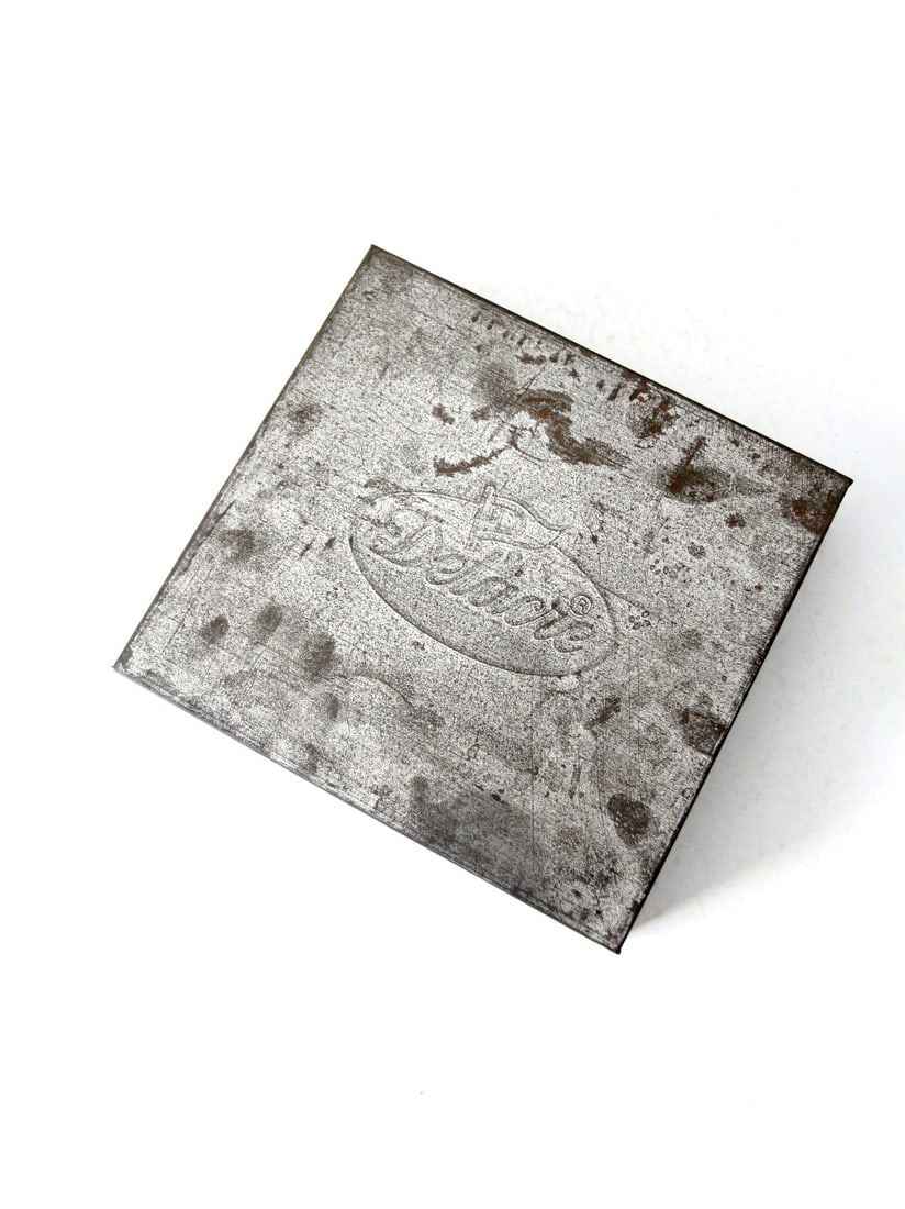 Vintage Delacre Square Tin Box Belgian Chocolatier 1894: Vintage Delacre Square Tin Box Belgian Chocolatier 1894 Discover a charming vintage metal tin from Delacre, a distinguished Belgian chocolatier founded in 1894. This square-shaped tin features a beaut