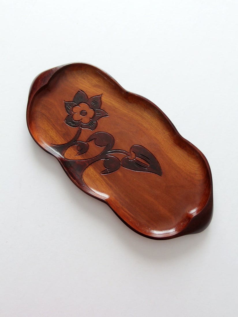 Carved Wooden Tray With Floral Motif and Warm Reddish Finish: Carved Wooden Tray With Floral Motif and Warm Reddish Finish This vintage carved wood tray from the 1960s-1970s features a warm reddish-brown finish and softly contoured edge. The tray showcases an in
