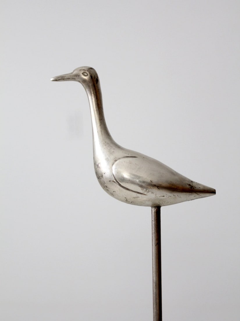 Chrome Modernist Bird Sculpture on Tall Pedestal Base 18 Inch: Chrome Modernist Bird Sculpture on Tall Pedestal Base 18 Inch This mid-century modern bird sculpture features a sleek chrome metal bird perched atop a long, slender pole with a round base. The minimal