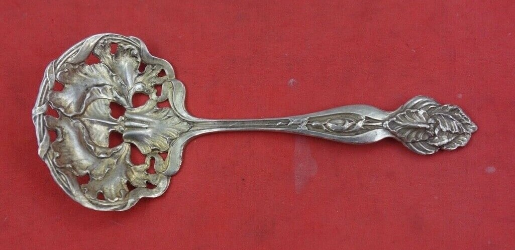 Shiebler Sterling Silver Nut Spoon Gold Washed Iris 4 3/4": Shiebler Sterling Silver Nut Spoon Gold Washed Iris 4 3/4" This exquisite nut spoon, crafted by Shiebler, showcases the elegance of sterling silver with a beautiful gold wash finish. The spoon is char