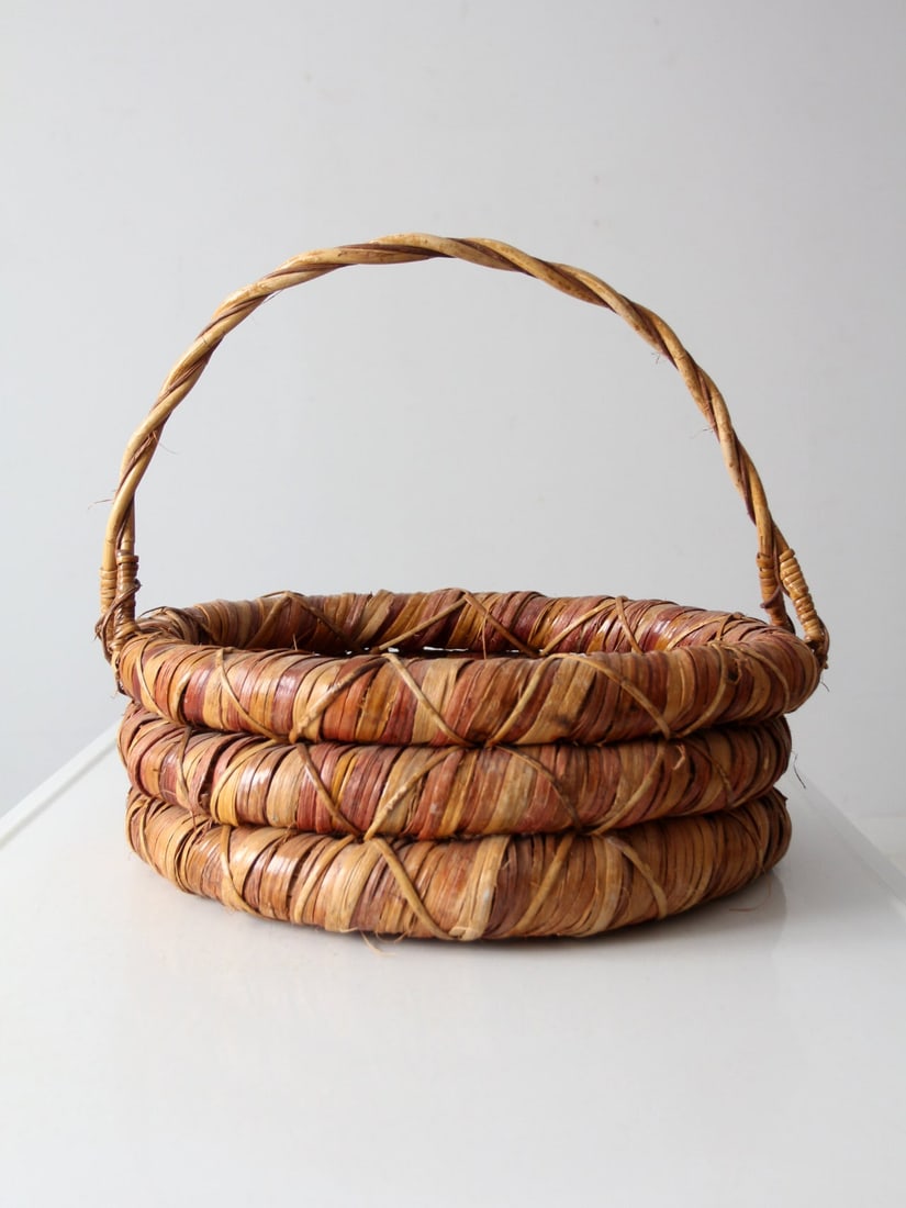 Vintage Woven Basket Natural Fiber Rustic Decor: Vintage Woven Basket Natural Fiber Rustic Decor This vintage woven gathering basket is expertly crafted from thick, coiled strands of natural fiber, showcasing warm tones of golden tan and russet. Its