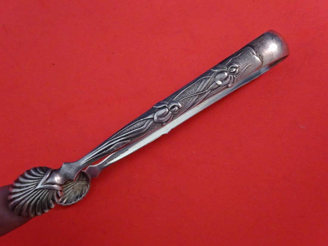 Tiffany & Co Vine Sterling Silver Sugar Tong Iris Shell Tines 4 3/4": Tiffany & Co Vine Sterling Silver Sugar Tong Iris Shell Tines 4 3/4" This exquisite sugar tong from Tiffany & Co. showcases the elegant Vine pattern, featuring an enchanting iris motif and graceful sh