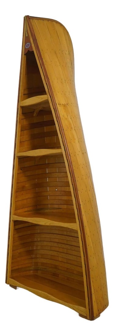 Bookcase Crafted From Antique North Bay Canoe With Brass Accents: Bookcase Crafted From Antique North Bay Canoe With Brass Accents This unique bookcase has been skillfully crafted from an original working canoe by the North Bay Canoe Company, showcasing high-quality