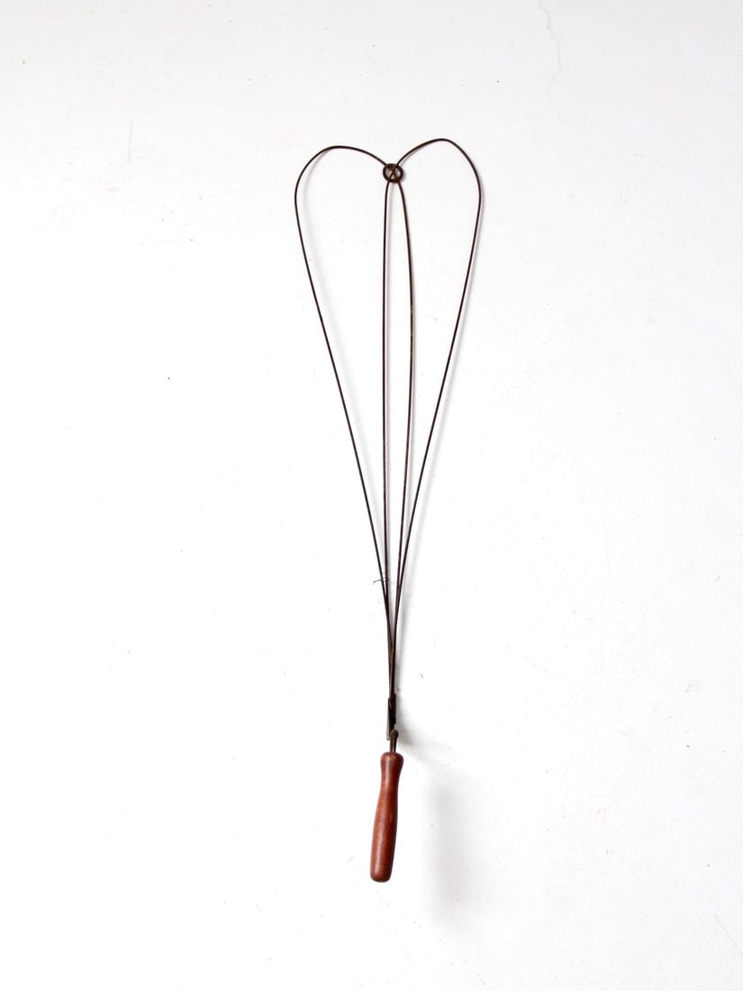 Primitive Wire and Wood Rug Beater with Turned Handle: Primitive Wire and Wood Rug Beater with Turned Handle This antique wire rug beater features a graceful silhouette crafted from slender wire with a turned wooden handle. The piece showcases an aged pat