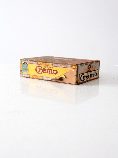 Vintage Cremo Wood Cigar Box with Colorful Advertising Labels: Vintage Cremo Wood Cigar Box with Colorful Advertising Labels This vintage Cremo wood cigar box features an attached lid adorned with colorful advertising paper labels. The exterior shows general wear