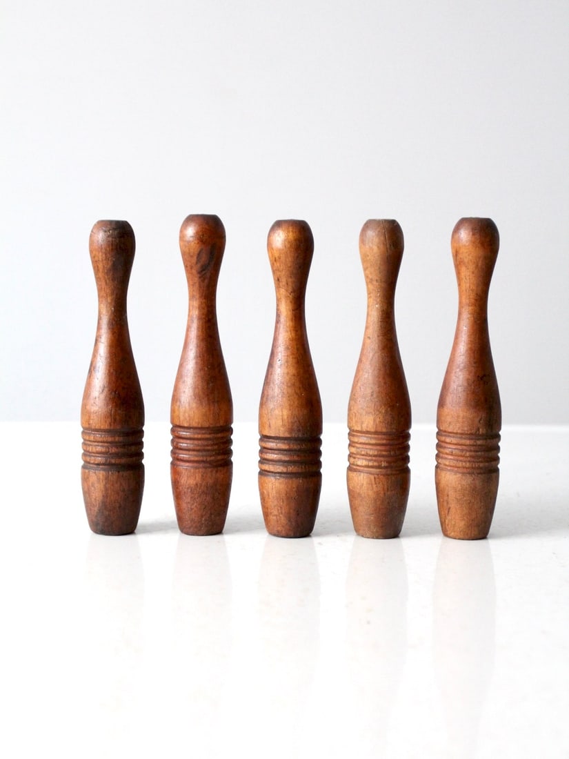 Five Antique Wooden Skittles Set Decorative Bowling Pins: Five Antique Wooden Skittles Set Decorative Bowling Pins This set includes five vintage wooden skittles, each displaying naturally aged wood tones and subtle variations. Perfect for adding visual inte